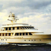 Luxury motor yacht Lady Alice cruising at open sea on calm water under clear sky